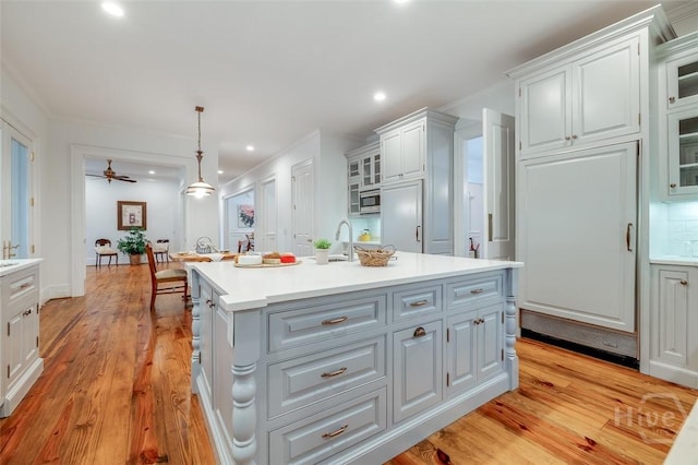 36 Belted Kingfisher Ln, Richmond Hill, GA 31324 - kitchen with white cabinets, light countertops, light wood-style flooring, recessed lighting, and crown molding