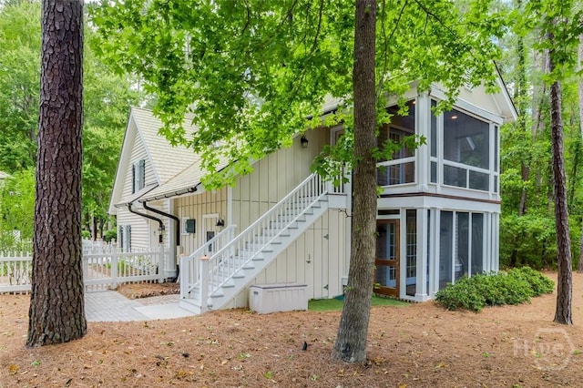 36 Belted Kingfisher Ln, Richmond Hill, GA 31324 - back of house featuring a sunroom and stairway
