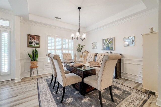 2 Iron Gate Ct, Pooler, GA 31322 - dining space featuring light wood-type flooring, a tray ceiling, a decorative wall, plenty of natural light, and crown molding