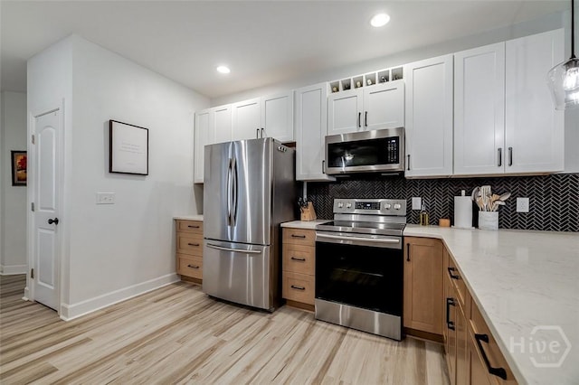 2 Iron Gate Ct, Pooler, GA 31322 - kitchen with stainless steel appliances, light wood finished floors, backsplash, light stone counters, and baseboards