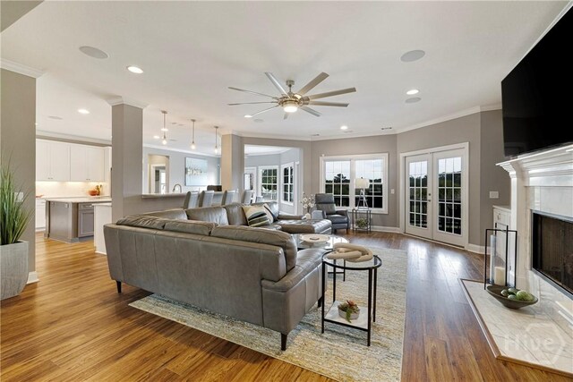 907 Cheryl St, Savannah, GA 31410 - living area featuring crown molding, a ceiling fan, light wood finished floors, french doors, and a high end fireplace