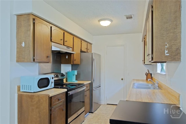 128 Deann Dr, Hinesville, GA 31313 - kitchen featuring stainless steel appliances, under cabinet range hood, a sink, light countertops, and a textured ceiling