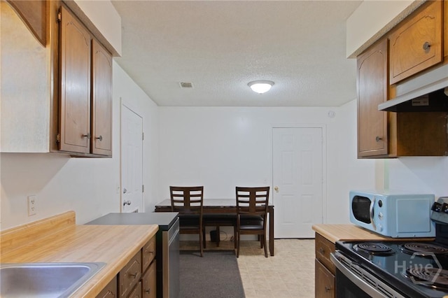 128 Deann Dr, Hinesville, GA 31313 - kitchen with electric range oven, light countertops, light floors, and white microwave