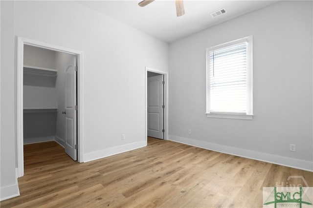 826 W Victory Dr, Savannah, GA 31405 - unfurnished bedroom featuring wood finished floors, a spacious closet, baseboards, and ceiling fan