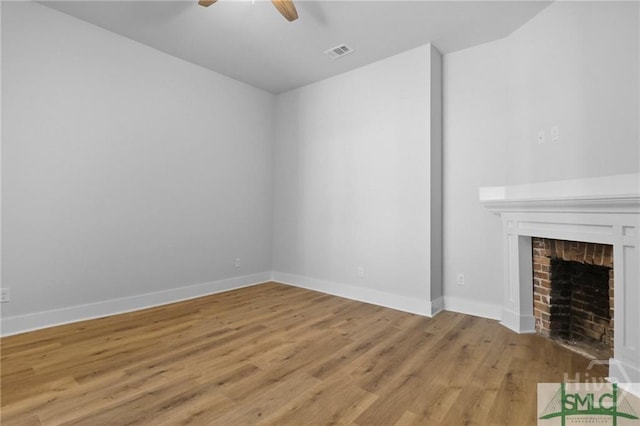 826 W Victory Dr, Savannah, GA 31405 - unfurnished living room with ceiling fan, light wood finished floors, a brick fireplace, and baseboards
