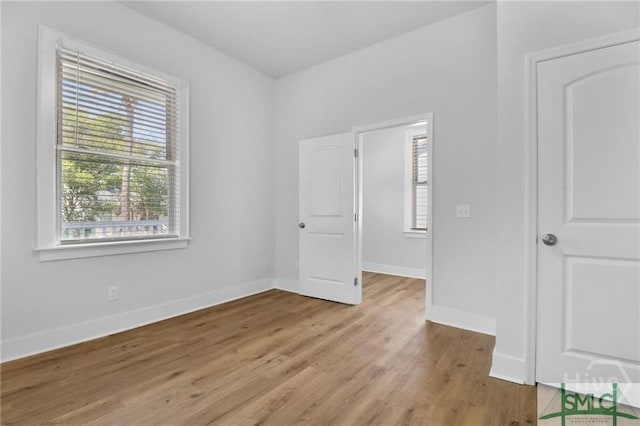 826 W Victory Dr, Savannah, GA 31405 - unfurnished bedroom featuring multiple windows, light wood-type flooring, and baseboards