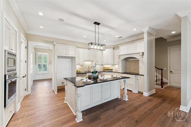 104 Post House Trl, Pooler, GA 31322 - kitchen with stainless steel appliances, dark countertops, decorative backsplash, wood finished floors, and crown molding