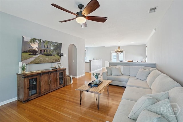 43 Godley Park Way, Savannah, GA 31407 - living room featuring light wood-type flooring, arched walkways, a chandelier, and a ceiling fan