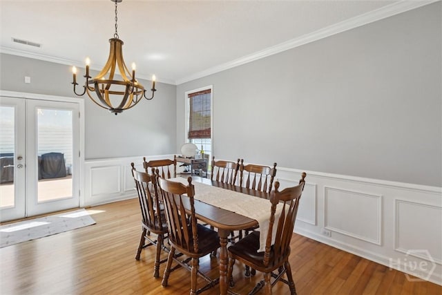 43 Godley Park Way, Savannah, GA 31407 - dining room featuring a decorative wall, french doors, crown molding, a chandelier, and light wood-type flooring