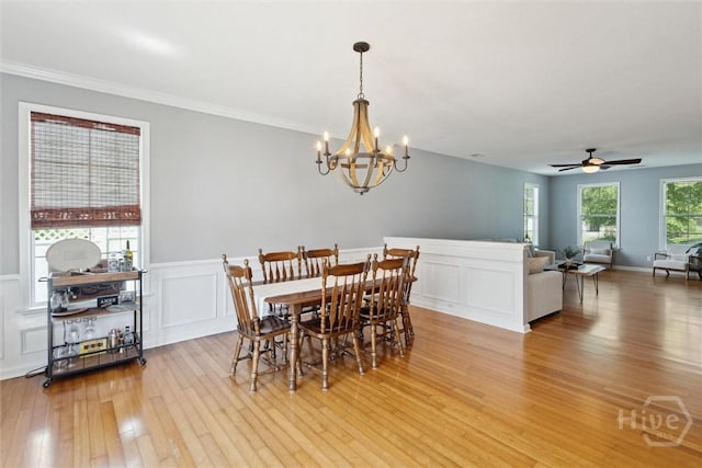 43 Godley Park Way, Savannah, GA 31407 - dining room featuring light wood-style flooring, a chandelier, a decorative wall, wainscoting, and crown molding