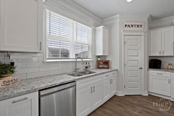 150 Pitch Point Trl, Richmond Hill, GA 31324 - kitchen with stainless steel dishwasher, a sink, white cabinets, decorative backsplash, and ornamental molding