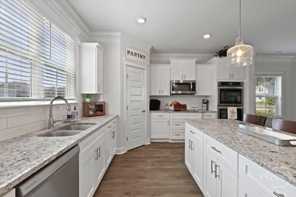 150 Pitch Point Trl, Richmond Hill, GA 31324 - kitchen with appliances with stainless steel finishes, a sink, ornamental molding, white cabinetry, and tasteful backsplash