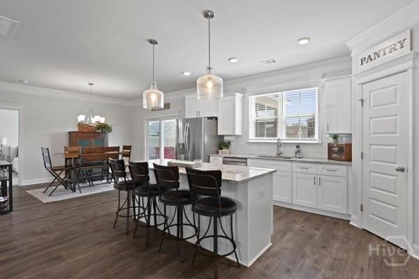 150 Pitch Point Trl, Richmond Hill, GA 31324 - kitchen featuring stainless steel refrigerator with ice dispenser, a kitchen island, white cabinets, a kitchen breakfast bar, and ornamental molding
