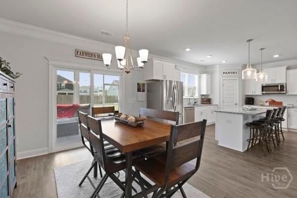 150 Pitch Point Trl, Richmond Hill, GA 31324 - dining space with ornamental molding, a chandelier, recessed lighting, and wood finished floors