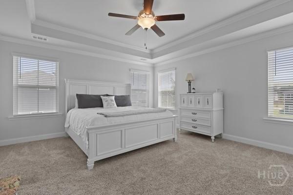 150 Pitch Point Trl, Richmond Hill, GA 31324 - bedroom featuring a tray ceiling, crown molding, light colored carpet, and baseboards