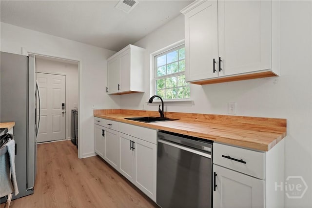 210 Walker Dr, Guyton, GA 31312 - kitchen featuring appliances with stainless steel finishes, a sink, light wood-type flooring, white cabinets, and butcher block countertops