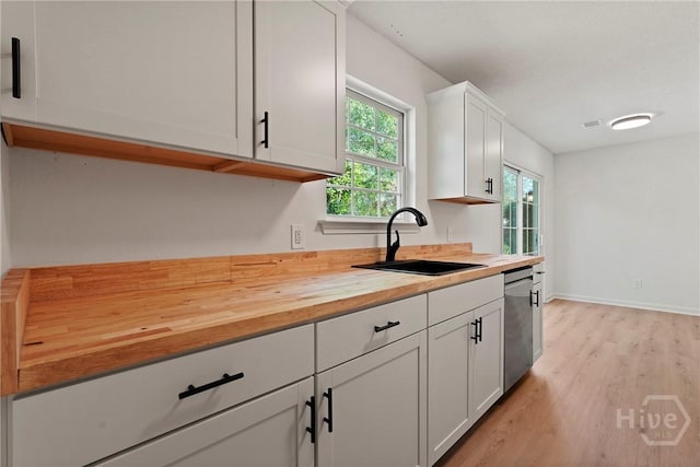 210 Walker Dr, Guyton, GA 31312 - kitchen with a sink, butcher block counters, dishwasher, light wood-type flooring, and white cabinetry