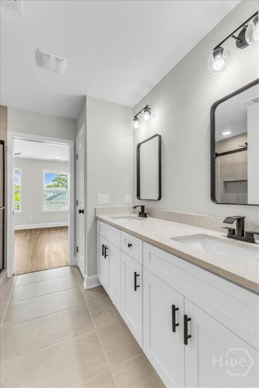 716 Waters Ave, Savannah, GA 31404 - full bath featuring double vanity, tile patterned flooring, a shower with shower door, and baseboards