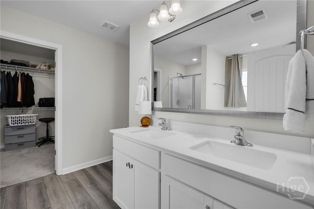 22 Stetson Dr, Savannah, GA 31419 - full bathroom featuring wood finished floors, a stall shower, double vanity, a walk in closet, and baseboards