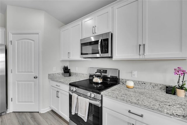22 Stetson Dr, Savannah, GA 31419 - kitchen with appliances with stainless steel finishes, white cabinets, light stone counters, and light wood-style flooring