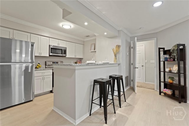 12300 Apache Ave Unit 1719, Savannah, GA 31419 - kitchen with appliances with stainless steel finishes, ornamental molding, light wood-type flooring, recessed lighting, and a breakfast bar
