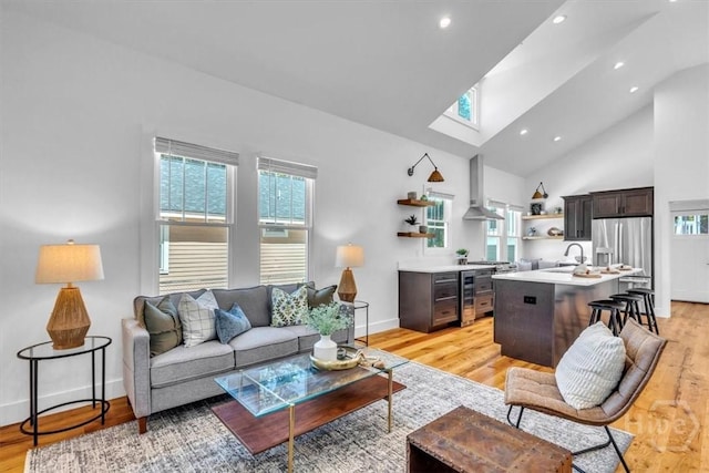 2136 Indiana Ave, Savannah, GA 31404 - living room featuring baseboards, a skylight, light wood-style floors, high vaulted ceiling, and recessed lighting