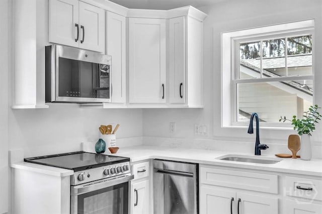 2136 Indiana Ave, Savannah, GA 31404 - kitchen with appliances with stainless steel finishes, a sink, white cabinets, and light countertops