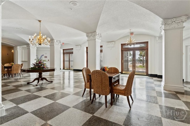 700 Wilmington Island Rd Unit 305, Savannah, GA 31410 - dining area with decorative columns, a chandelier, vaulted ceiling, baseboards, and a textured ceiling