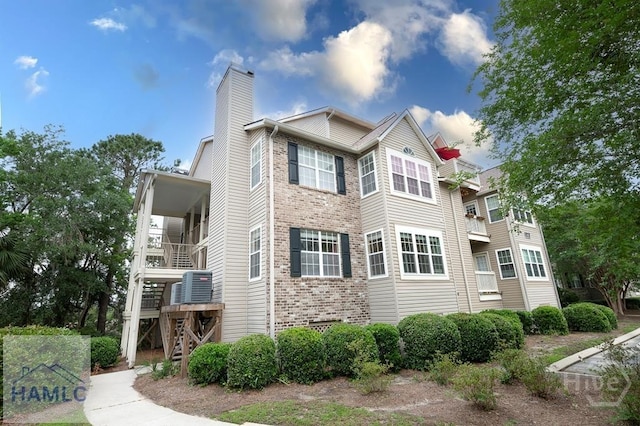 12300 Apache Ave Unit 604, Savannah, GA 31419 - view of property exterior with stairs, brick siding, a chimney, and central AC