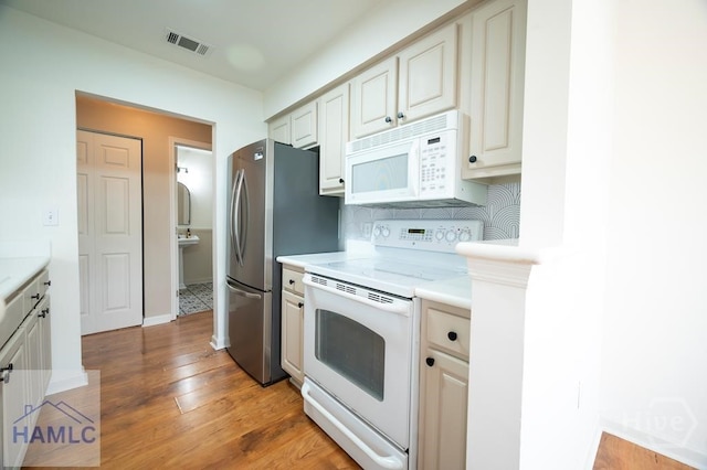12300 Apache Ave Unit 604, Savannah, GA 31419 - kitchen featuring white appliances, light countertops, light wood-style flooring, and tasteful backsplash