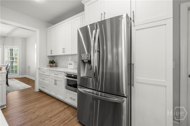 117 Myrtlewood Dr, Guyton, GA 31312 - kitchen featuring stainless steel appliances, wood finished floors, light countertops, white cabinetry, and backsplash