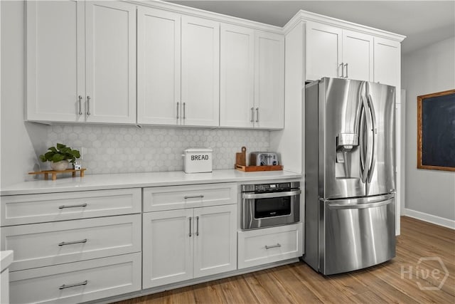117 Myrtlewood Dr, Guyton, GA 31312 - kitchen with stainless steel appliances, light countertops, white cabinets, tasteful backsplash, and wood finished floors