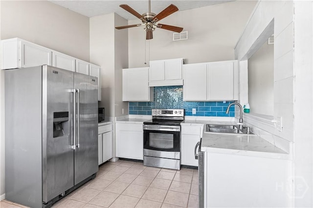 103 Mapmaker Cv, Savannah, GA 31410 - kitchen with stainless steel appliances, a sink, backsplash, white cabinets, and light tile patterned flooring