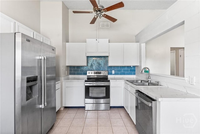 103 Mapmaker Cv, Savannah, GA 31410 - kitchen with stainless steel appliances, a sink, a ceiling fan, white cabinetry, and high vaulted ceiling