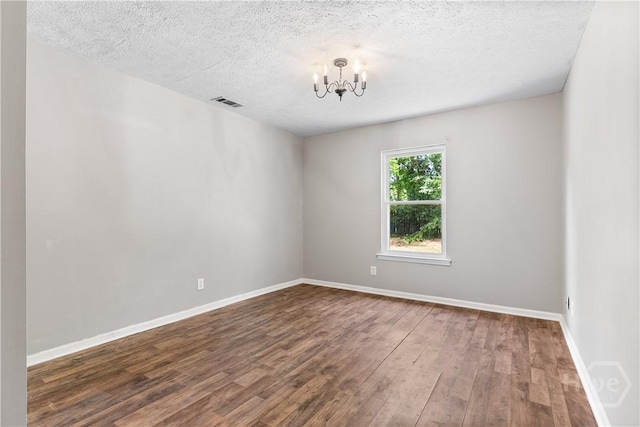 103 Mapmaker Cv, Savannah, GA 31410 - spare room featuring a chandelier, wood finished floors, a textured ceiling, and baseboards
