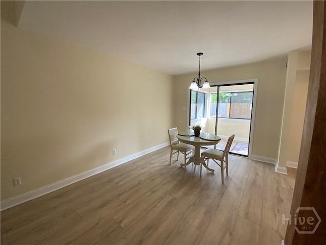 61 Port Dr, Richmond Hill, GA 31324 - dining space featuring wood finished floors, a chandelier, and baseboards
