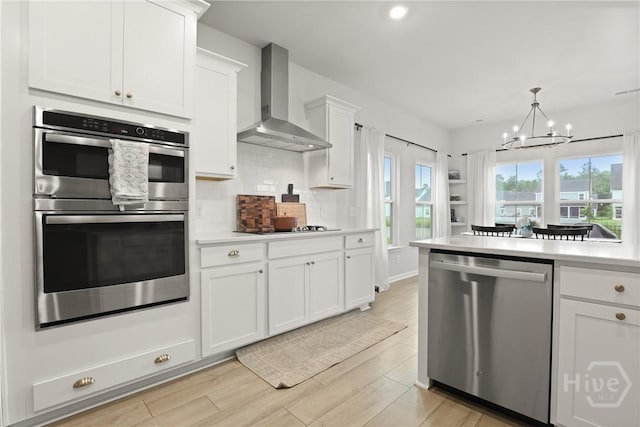137 Binscombe Ln, Pooler, GA 31322 - kitchen featuring appliances with stainless steel finishes, wall chimney exhaust hood, a chandelier, light countertops, and backsplash