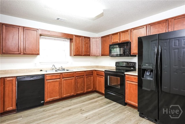 42 Tiller Way, Port Wentworth, GA 31407 - kitchen featuring black appliances, light countertops, light wood finished floors, a textured ceiling, and brown cabinets