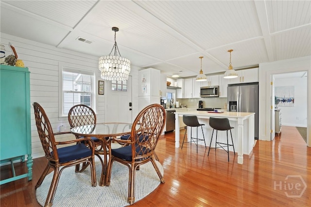 132 Pelican Dr, Tybee Island, GA 31328 - dining space with a chandelier and light wood-style floors