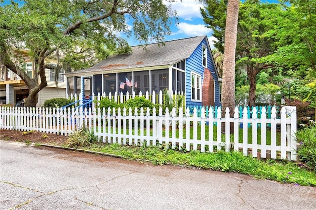 14 Bright St, Tybee Island, GA 31328 - bungalow-style house with a sunroom, a fenced front yard, and roof with shingles