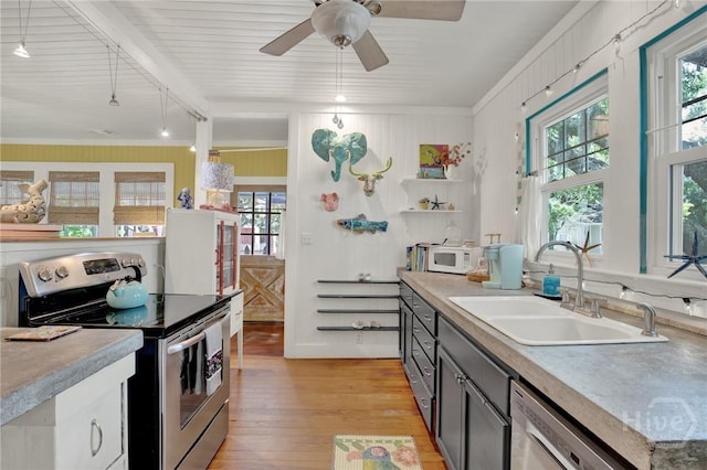 14 Bright St, Tybee Island, GA 31328 - kitchen featuring stainless steel appliances, a sink, healthy amount of natural light, and light wood-style floors