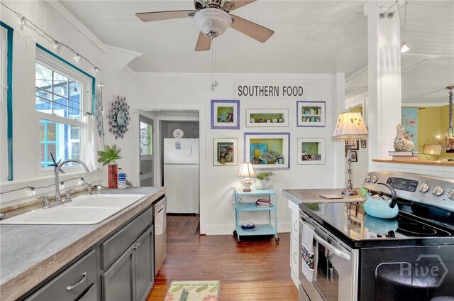 14 Bright St, Tybee Island, GA 31328 - kitchen featuring stainless steel appliances, a sink, gray cabinetry, dark wood-style flooring, and ornamental molding