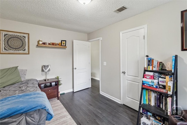 2000 Ossabaw Dr, Hinesville, GA 31313 - bedroom with dark wood-style floors, a textured ceiling, and baseboards