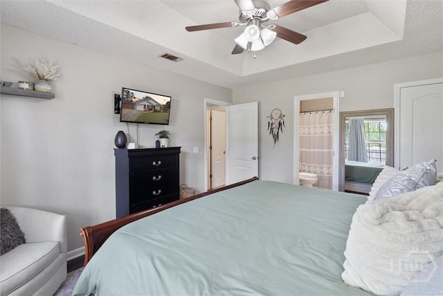 2000 Ossabaw Dr, Hinesville, GA 31313 - bedroom featuring a raised ceiling, connected bathroom, and ceiling fan