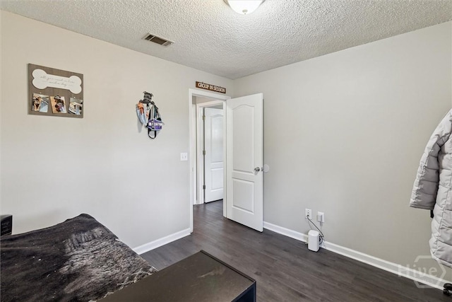 2000 Ossabaw Dr, Hinesville, GA 31313 - unfurnished bedroom featuring dark wood-style flooring, baseboards, and a textured ceiling