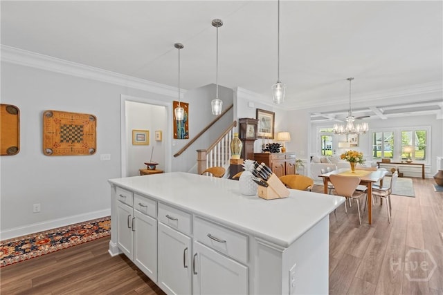 117 Quince St, Pooler, GA 31322 - kitchen with open floor plan, light wood-style floors, ornamental molding, decorative light fixtures, and white cabinetry