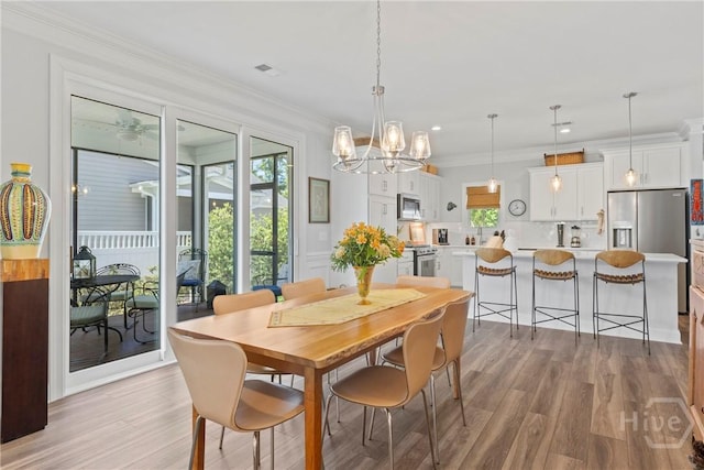 117 Quince St, Pooler, GA 31322 - dining area featuring light wood-style flooring, a chandelier, and crown molding