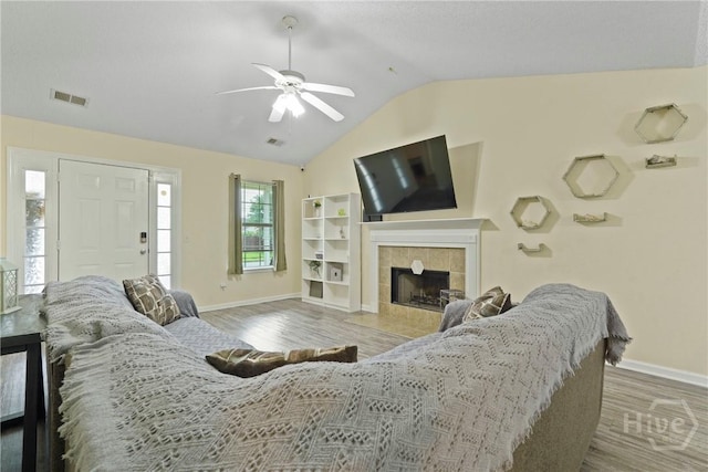21 Hawser Way, Port Wentworth, GA 31407 - living room featuring baseboards, vaulted ceiling, a tiled fireplace, ceiling fan, and wood finished floors