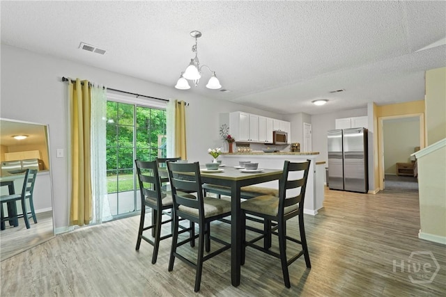 21 Hawser Way, Port Wentworth, GA 31407 - dining room featuring a textured ceiling, a chandelier, light wood-style flooring, baseboards, and stairway