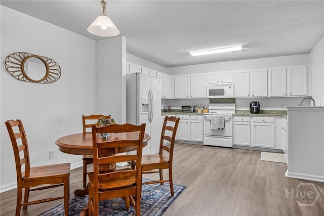 231 Tigers Paw Dr, Pooler, GA 31322 - kitchen with white appliances, light wood-style flooring, white cabinetry, pendant lighting, and a textured ceiling